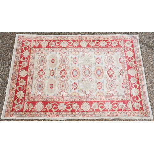 750 - A contemporary pale camel and red ground Agra carpet, traditional repeating design, 314 cm x 210 cm