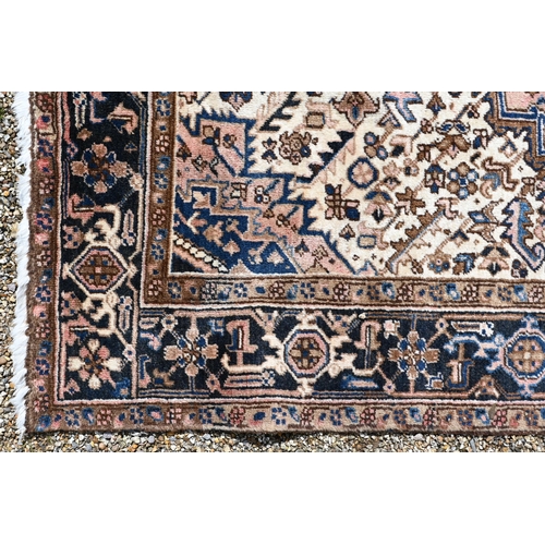 752 - A contemporary Persian Heriz carpet, the traditional geometric designs on blue ground, centred by a ... 