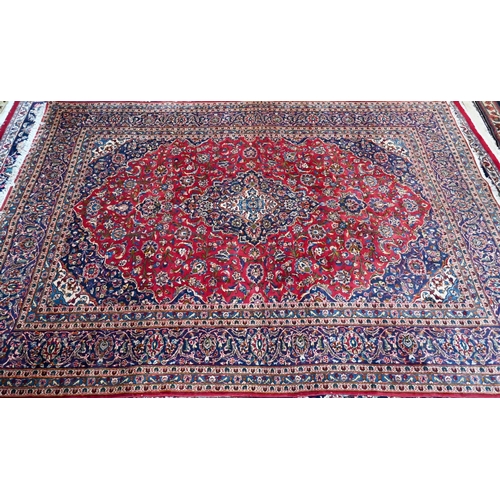 753 - An old Persian kashan carpet, the mid blue ground with floral medallion, 337 cm x 244 cm