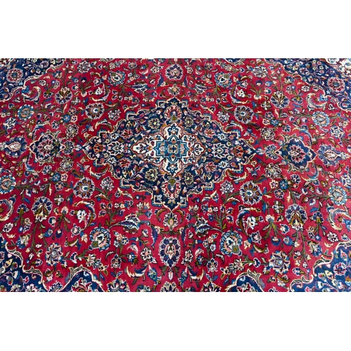 753 - An old Persian kashan carpet, the mid blue ground with floral medallion, 337 cm x 244 cm