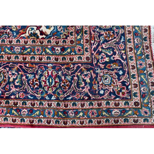 753 - An old Persian kashan carpet, the mid blue ground with floral medallion, 337 cm x 244 cm