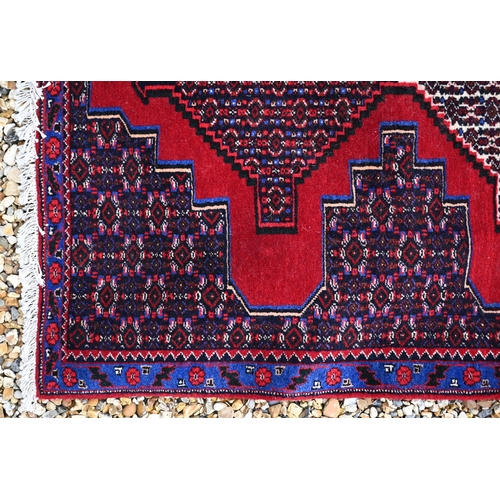 755 - A North West Persian Senneh runner, the blue/red ground with diamond pole design, 400 cm x 100 cm