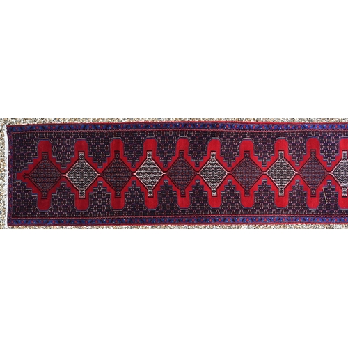 755 - A North West Persian Senneh runner, the blue/red ground with diamond pole design, 400 cm x 100 cm