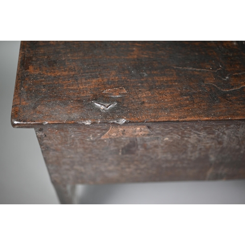 807 - A diminutive 17th century boarded oak and elm chest, the hinged top over a carved palm leaf design, ... 