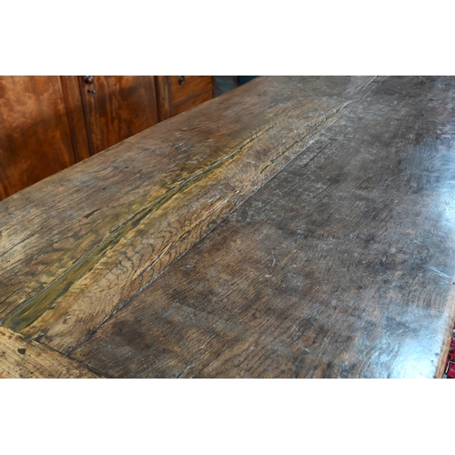 833 - A 17th century and later composed oak refectory table, the wide two plank top with cleated ends rais... 