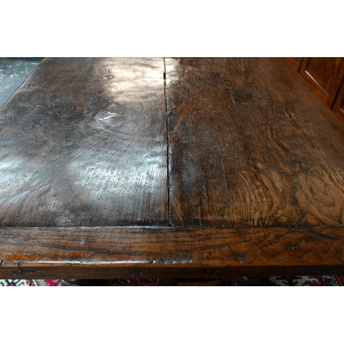 833 - A 17th century and later composed oak refectory table, the wide two plank top with cleated ends rais... 