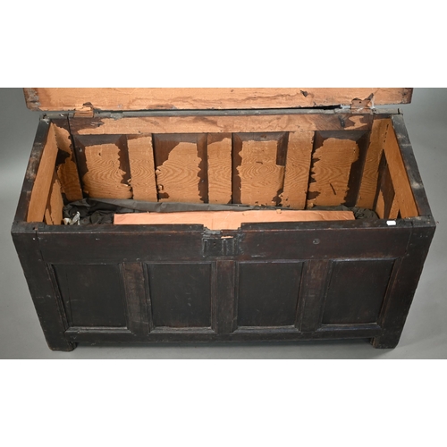 857 - An early 18th century joint oak coffer, the triple plank top over a four panel front an raised on st... 