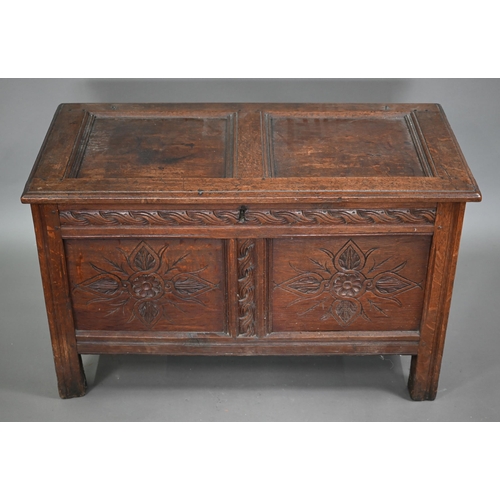 858 - A late 17th century carved joint oak coffer, the staple hinged top over two floral carved panels, on... 