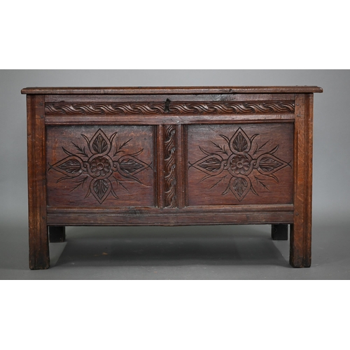 858 - A late 17th century carved joint oak coffer, the staple hinged top over two floral carved panels, on... 