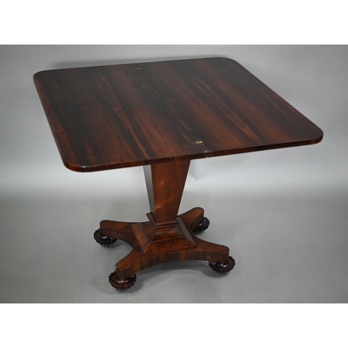 876 - A Victorian rosewood tea table, the fold over top raised on a square tapering support to a shaped qu... 