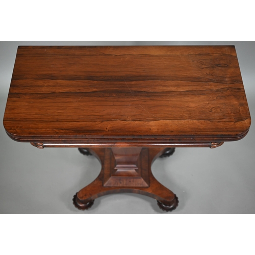 876 - A Victorian rosewood tea table, the fold over top raised on a square tapering support to a shaped qu... 