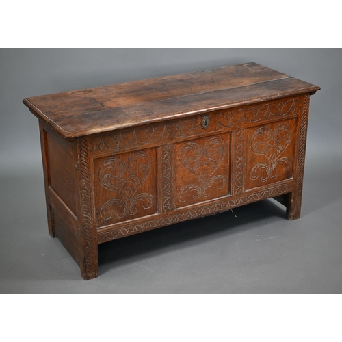 879 - A late 17th century joint oak coffer, the plank top over a triple heart design carved front, on stil... 