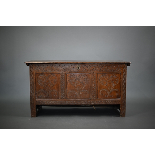 879 - A late 17th century joint oak coffer, the plank top over a triple heart design carved front, on stil... 