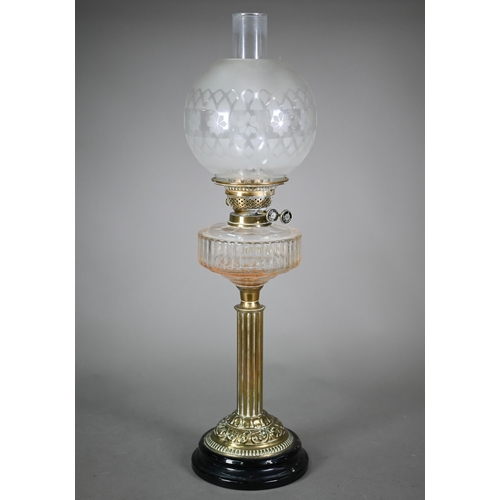 904 - An antique brass column and etched glass shade oil lamp, raised on a brown glazed pottery base, 67 c... 