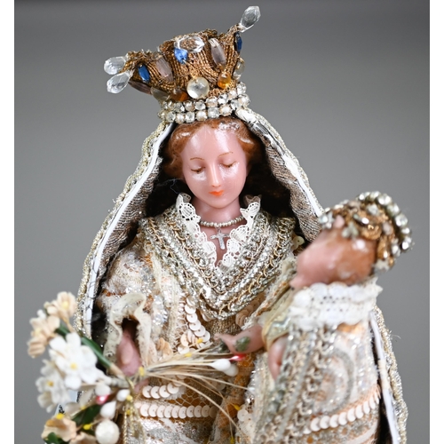 981 - A wax Madonna and Child figure in ornate embroidered and sequined robes, the plinth inscribed 'Monst... 