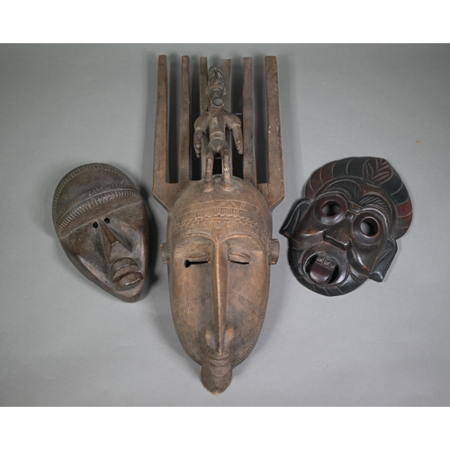 987 - A Bambara (Mali) carved wood mask with six-tooth 'comb' top supporting a male figure with pipe, 64 c... 