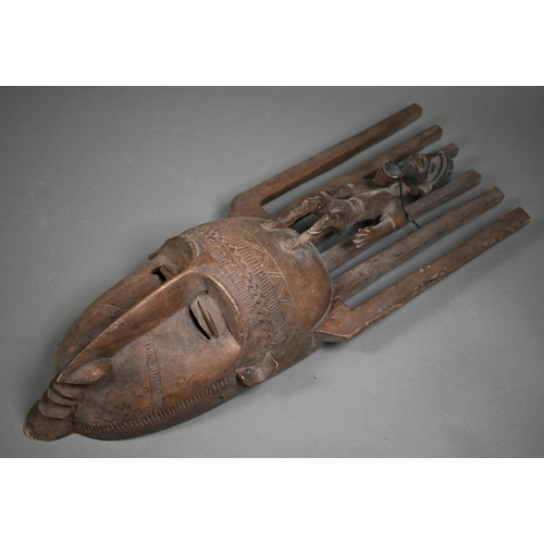 987 - A Bambara (Mali) carved wood mask with six-tooth 'comb' top supporting a male figure with pipe, 64 c... 