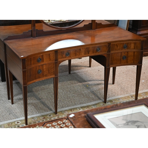 821 - A companion pair of mahogany dressing tables, of concave outline, one with a mirrored back over an a... 