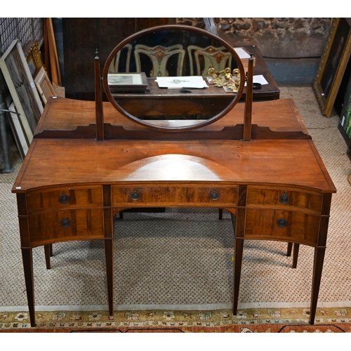 821 - A companion pair of mahogany dressing tables, of concave outline, one with a mirrored back over an a... 