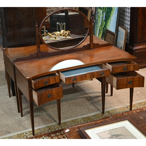 821 - A companion pair of mahogany dressing tables, of concave outline, one with a mirrored back over an a... 