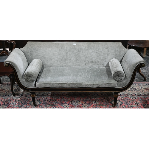 841 - A Regency brass mounted ebonised and gilt scroll end sofa, in champagne upholstery and raised on tur... 