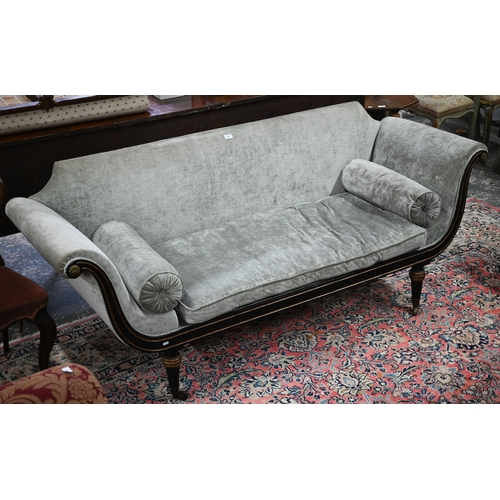 841 - A Regency brass mounted ebonised and gilt scroll end sofa, in champagne upholstery and raised on tur... 