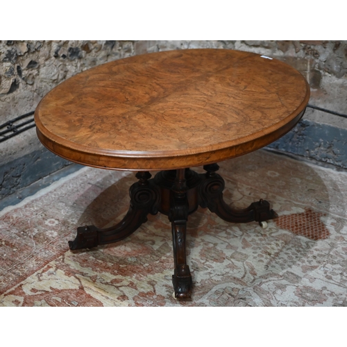 878 - A Victorian figured walnut oval tilt top loo/breakfast table, raised on four turned columns to mould... 