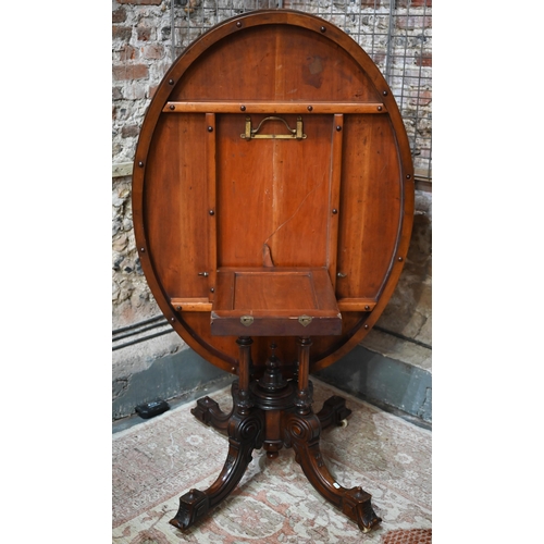 878 - A Victorian figured walnut oval tilt top loo/breakfast table, raised on four turned columns to mould... 