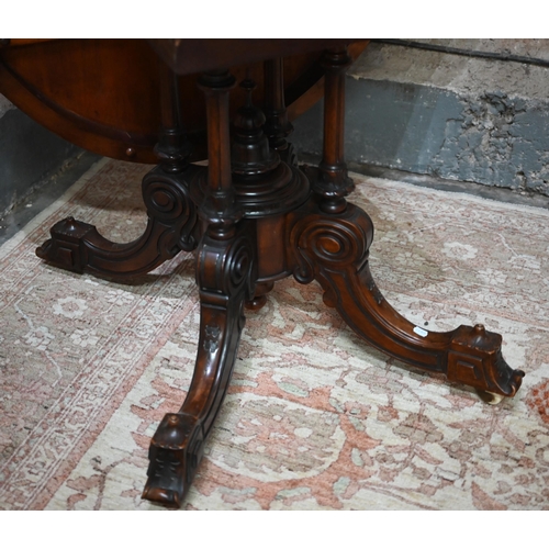 878 - A Victorian figured walnut oval tilt top loo/breakfast table, raised on four turned columns to mould... 