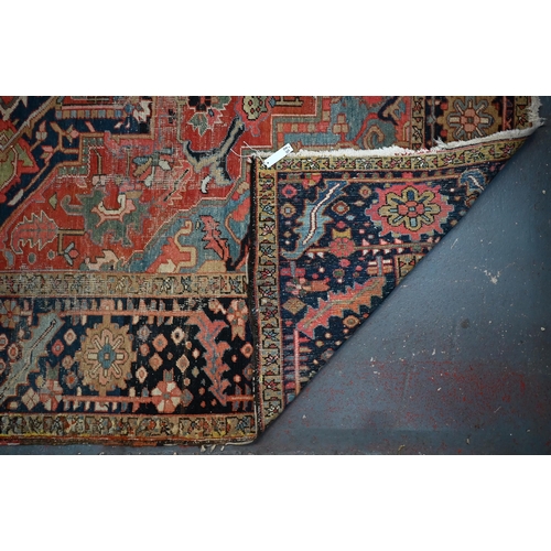 720 - An antique Persian Heriz carpet, the centre  medallion design on pale blue and camel ground, 340 cm ... 