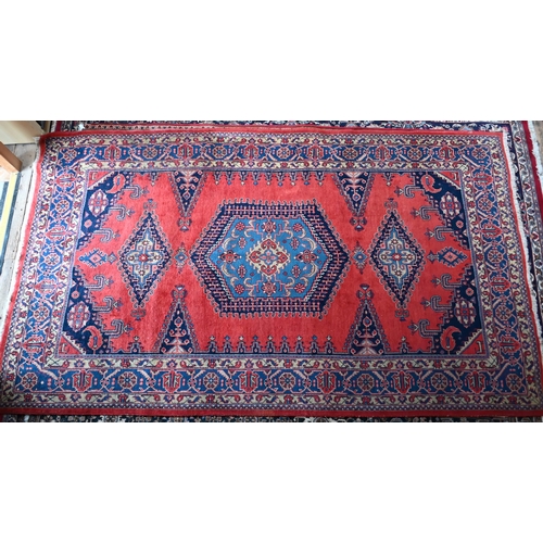 751 - A Persian Hamadan carpet, the red/blue ground centred by a medallion, 216 cm x 372 cm