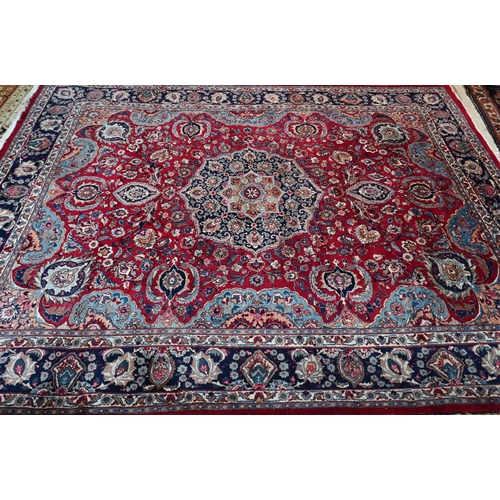 754 - A contemporary Persian Kashan carpet, the blue ground with mult-coloured geometric design, 384 cm x ... 