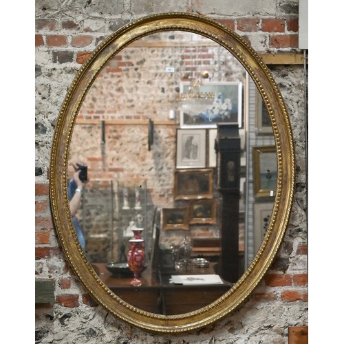 862 - A large Victorian oval giltwood framed mirror, 145 cm x 112 cm