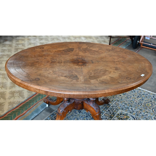 104 - A Victorian walnut and satin inlaid loo table with oval quarter-veneered top on four turned pillars ... 