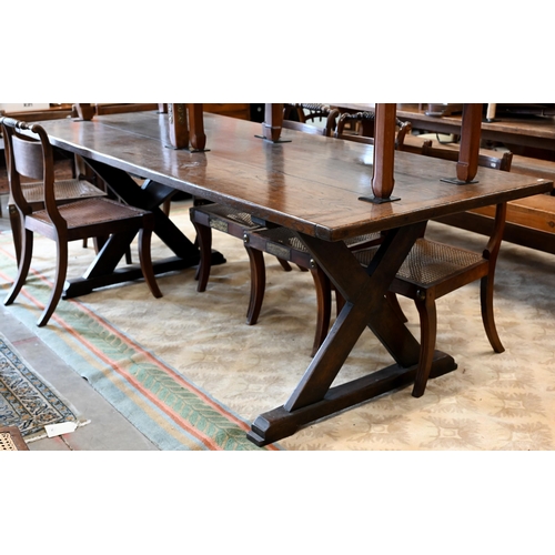 110 - An oak refectory dining table with cleated triple plank top on braced cross-trestle supports, 230 x ... 