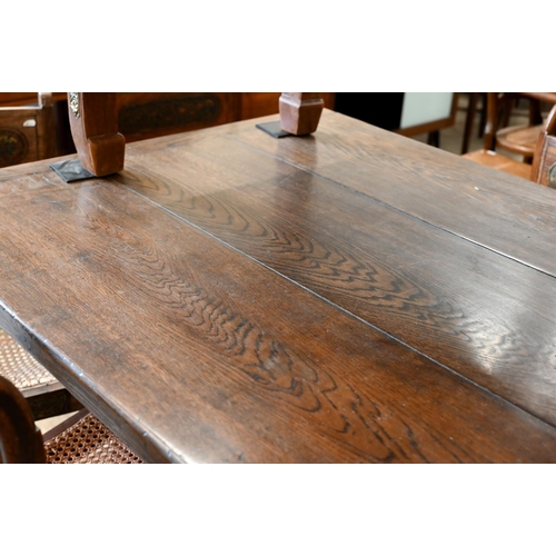 110 - An oak refectory dining table with cleated triple plank top on braced cross-trestle supports, 230 x ... 