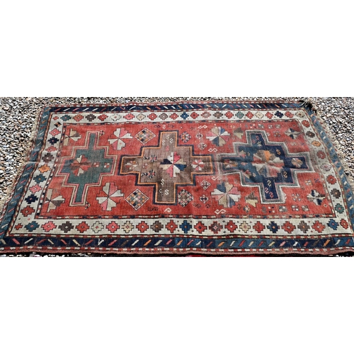 126 - Old worn caucasian rug, with geometric triple medallion design on red ground, cream/blue borders, 19... 