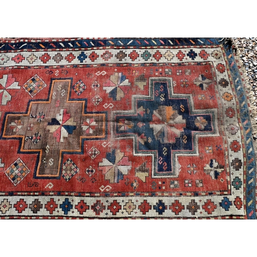 126 - Old worn caucasian rug, with geometric triple medallion design on red ground, cream/blue borders, 19... 