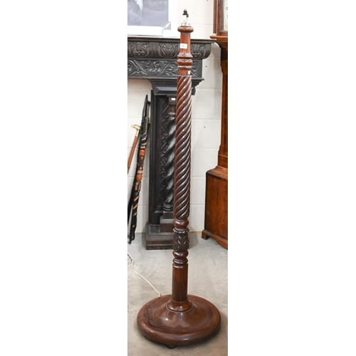 136 - A mahogany turned spiral reeded standard lamp on circular base, 160 cm high