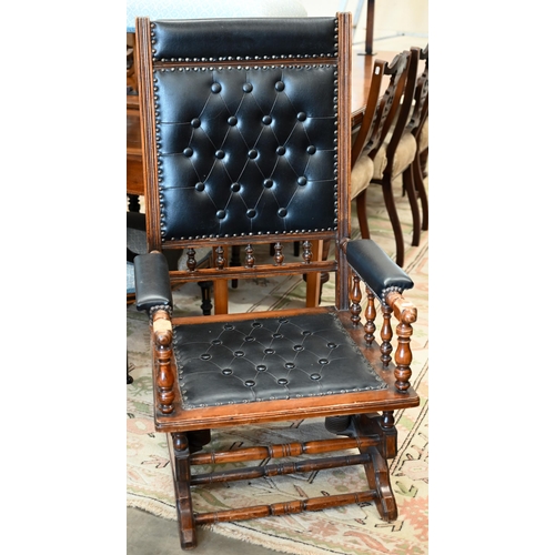 140 - # An early 20th century walnut framed American rocking chair, in buttoned black leatherette