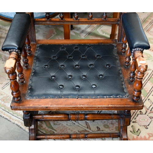 140 - # An early 20th century walnut framed American rocking chair, in buttoned black leatherette