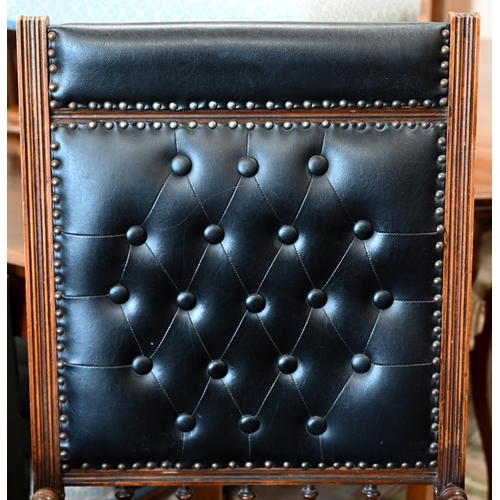 140 - # An early 20th century walnut framed American rocking chair, in buttoned black leatherette