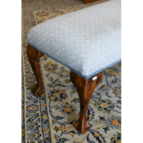 141 - A walnut framed footstool with blue and white patterned fabric and cabriole supports, 108 x 40 x 42 ... 