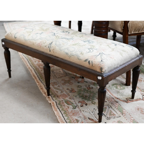 141A - A low rectangular stool with six reeded supports and floral tapestry seat, 40 x 90 x 35 cm high