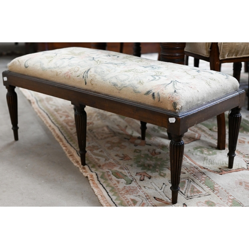 141A - A low rectangular stool with six reeded supports and floral tapestry seat, 40 x 90 x 35 cm high