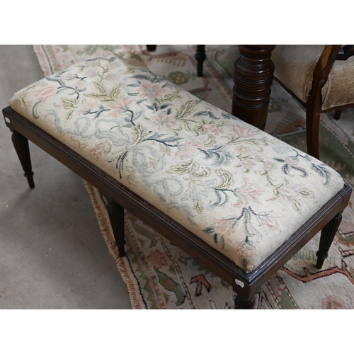 141A - A low rectangular stool with six reeded supports and floral tapestry seat, 40 x 90 x 35 cm high