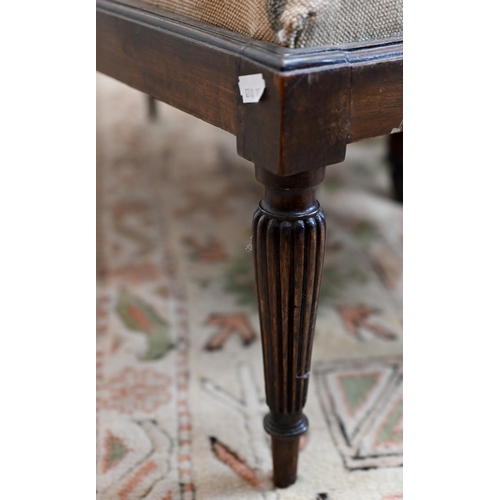 141A - A low rectangular stool with six reeded supports and floral tapestry seat, 40 x 90 x 35 cm high