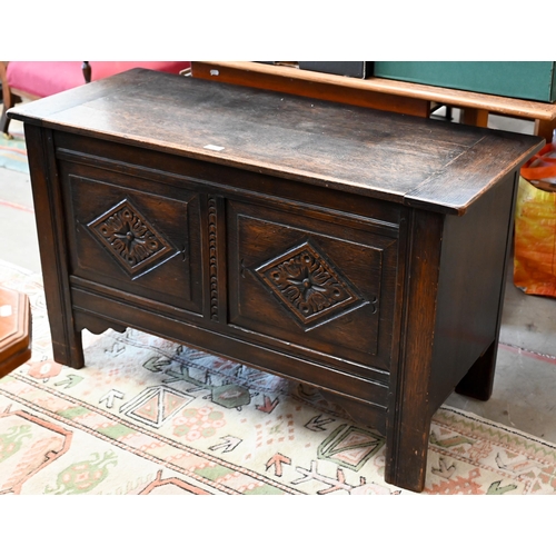 145 - # A dark oak coffer with hinged top and carved front panels, 106 x 46 x 64 cm high