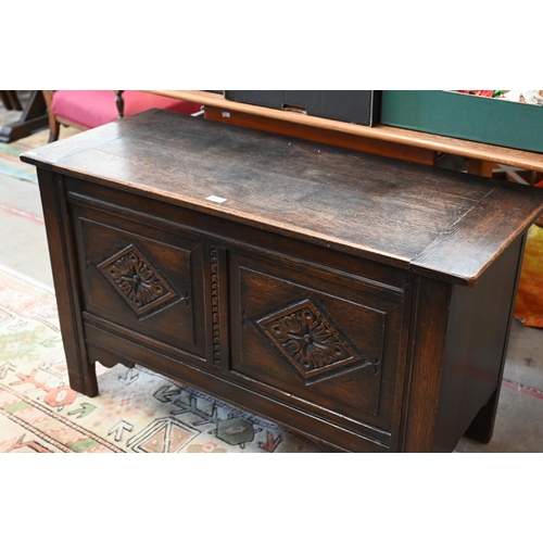 145 - # A dark oak coffer with hinged top and carved front panels, 106 x 46 x 64 cm high