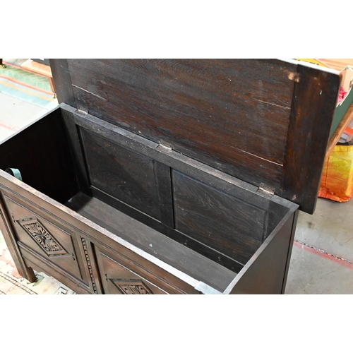 145 - # A dark oak coffer with hinged top and carved front panels, 106 x 46 x 64 cm high